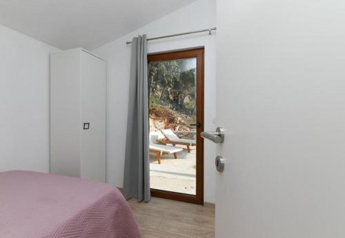 a bedroom with a door leading to a patio at House Irena in Pučišća