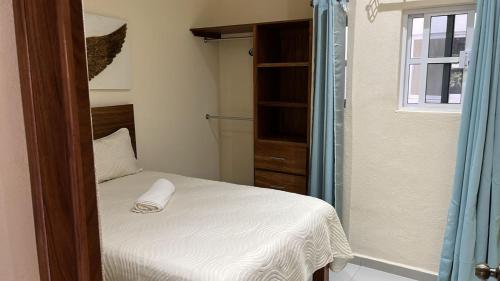 a small bedroom with a bed and a shower at Bungalows El Cielo in San Patricio Melaque