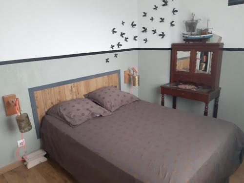 - une chambre avec un lit et une table avec un miroir dans l'établissement La maison du Bonheur, à Bénesse-Maremne