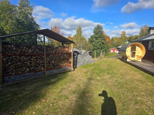 a shadow of a person standing next to a fence at Stuga10 elBastu & badtunna in Karlsborg
