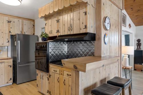 a kitchen with wooden cabinets and a refrigerator at California Dreamin by AvantStay Private Pool Fire Pit Near the Beach in Carlsbad