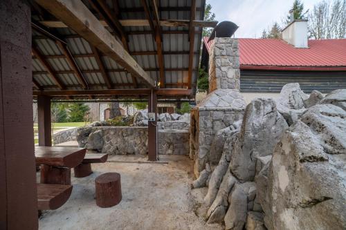 a stone building with a bench and a stone wall at CASA NATURA - charming chalet with hot tub in Tuk Vojni