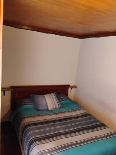 a small bedroom with a bed in a room at Alta Frontera Hostal in Los Ángeles