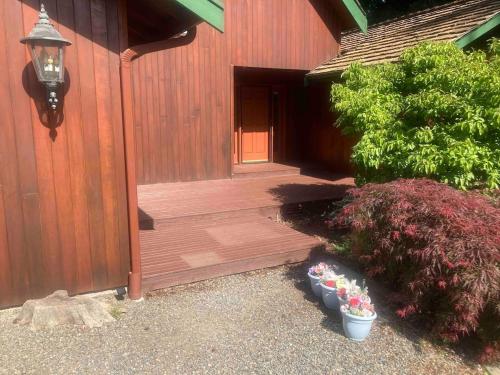 a porch of a house with some plants and flowers at Beautiful Lake Lodge with Huge Private Dock in Spanaway