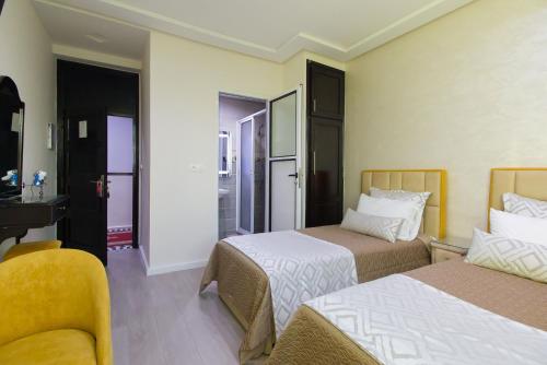 a hotel room with two beds and a bathroom at Mamora Bay in Tangier