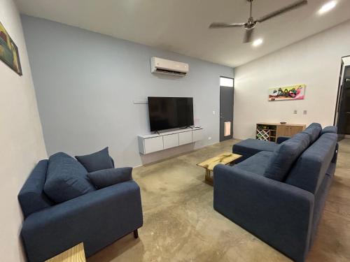 a living room with two blue couches and a flat screen tv at Bravo paraiso azul beach house in Savegre