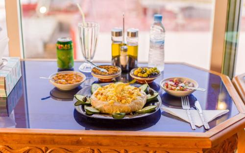 a table with a plate of food and bowls of food at Mamora Bay in Tangier