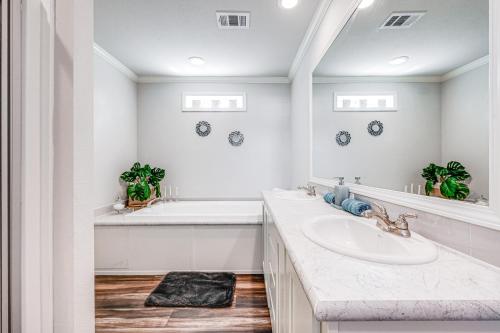 布罗肯鲍Lovely Broken Bow Cottage with Hot Tub and Fire Pit!的一间白色浴室，配有洗手池和镜子。