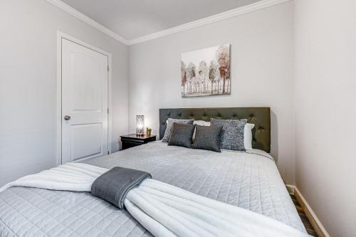 布罗肯鲍Lovely Broken Bow Cottage with Hot Tub and Fire Pit!的白色卧室配有一张带灰色枕头的大床