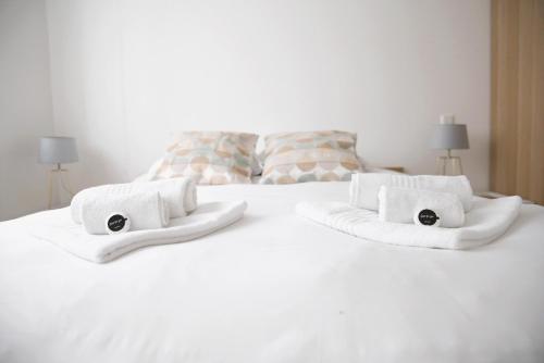 a white bed with towels and pillows on it at Peaceful 1BR Apartment with Garden in Esch-sur-Alzette