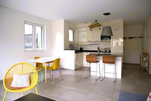 a kitchen and dining room with a table and chairs at Peaceful 1BR Apartment with Garden in Esch-sur-Alzette
