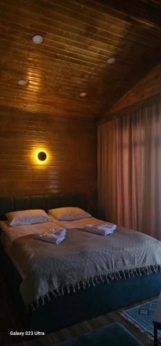 a bed in a room with a wooden ceiling at Cottage Talu in Mestia in Mestia