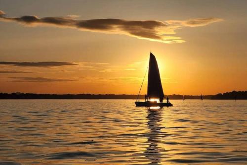 a sail boat in the water at sunset at Cool Spring Suite in Arnold