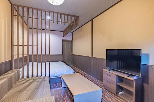 a small room with a bed and a television at Sengokuhara Shinanoki Ichinoyu in Hakone