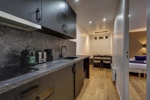 une cuisine avec un comptoir et une chambre avec un lit dans l'établissement Modern and renovated apartment next to Sacré-Coeur, à Paris