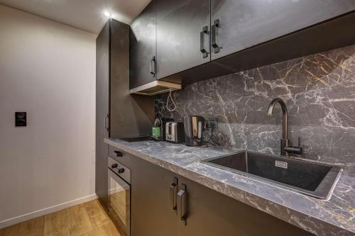 une cuisine avec un évier et un plan de travail dans l'établissement Modern and renovated apartment next to Sacré-Coeur, à Paris