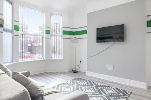 a living room with a couch and a tv at Contractor Luxury Home - Long Stays - 4 Bedrooms - Sleep 8 - Zip & Link Beds - Ultra Fast WiFi - Free Parking in Birkenhead