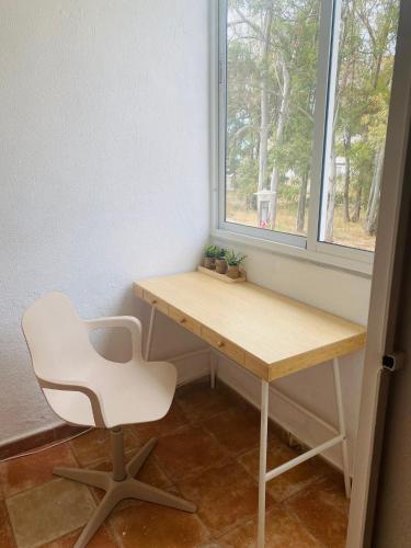 a desk and a chair in a room with a window at IslaOC Apartamentos - Adosado Villaparaiso in Isla Cristina