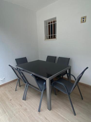 a black table and chairs in a room at IslaOC Apartamentos - Adosado Villaparaiso in Isla Cristina