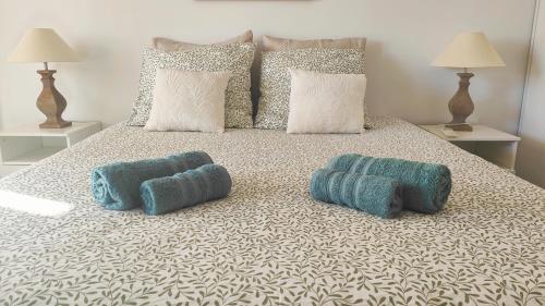 - un lit avec 2 oreillers bleus dans l'établissement Le Duplex Côté Vieux Port LA CIOTAT, à La Ciotat