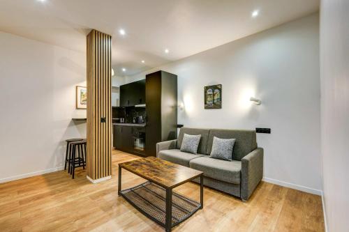 un salon avec un canapé et une table dans l'établissement Cozy and modern next to Sacré-Coeur, à Paris