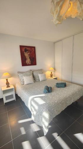 une chambre avec un grand lit et deux lampes dans l'établissement Le Duplex Côté Vieux Port LA CIOTAT, à La Ciotat