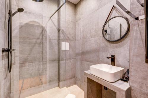 une salle de bain avec un lavabo et une douche avec un miroir dans l'établissement Cozy and modern next to Sacré-Coeur, à Paris