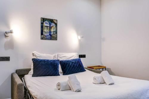 une chambre avec un lit avec des oreillers bleus et blancs dans l'établissement Cozy and modern next to Sacré-Coeur, à Paris