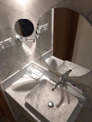 a bathroom sink with a mirror on top of it at الوعل للشقق الفندقية بالارطاوية in Al Arţāwīyah