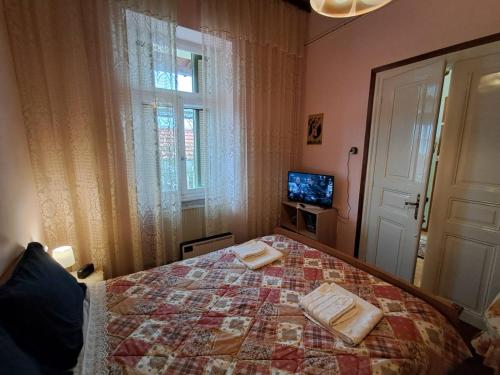 a bedroom with a bed and a tv and a window at Giannis and Aristi's House in Kavala