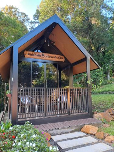 a gazebo with chairs and a sign on it at Cabana do Mato Waldhütte in Treze Tílias