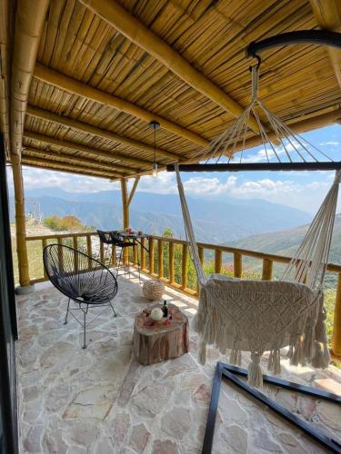 a porch with a hammock and a table and chairs at Mambe refugio in Piedecuesta