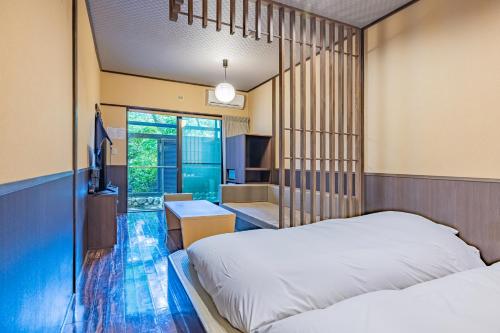 a bedroom with a bed and a desk and a bathroom at Sengokuhara Shinanoki Ichinoyu in Hakone