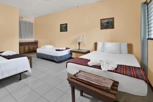 une chambre d'hôtel avec deux lits et une table dans l'établissement Drift Inn Cayo, à Santa Elena