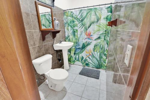 une salle de bain avec toilettes et douche dans l'établissement Drift Inn Cayo, à Santa Elena