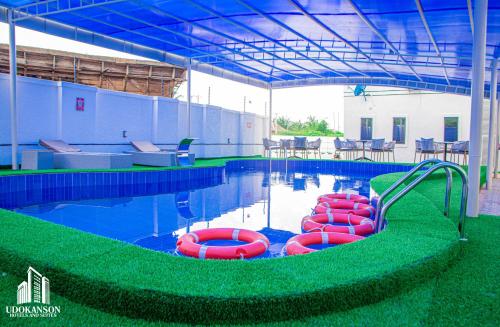 a swimming pool with red inflatable tubes in the water at Udokanson Hotel And Suites in Agbor
