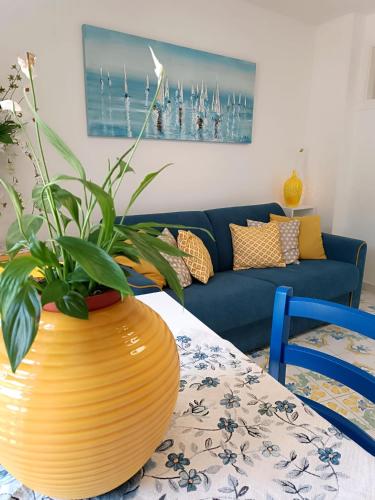 a living room with a blue couch and a vase with a plant at Il giardino dei limoni in Minori