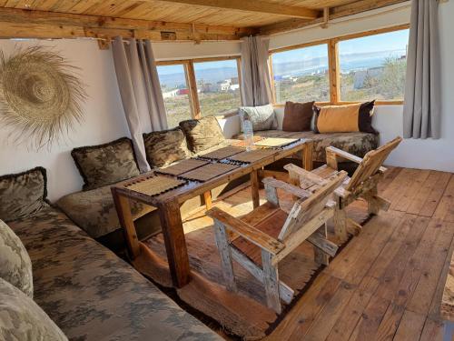 a living room with a wooden table and a couch at Fisherman House in Wassane