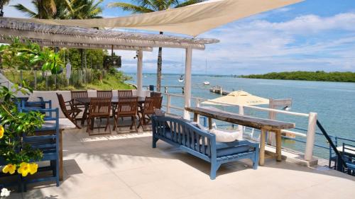 a patio with a table and chairs and the water at Restaurante & Pousada Gaivota in Santo André