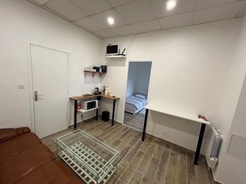 un salon avec un canapé, une table et un bureau dans l'établissement Quiet apartment area, à Vitry-sur-Seine