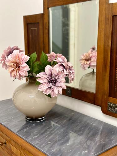 a vase filled with pink flowers sitting on a counter at Casa Iovis in Casagiove
