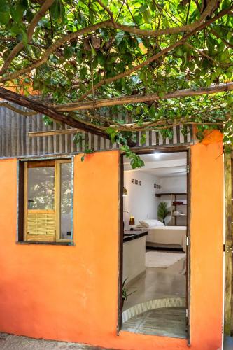 an orange door opens to a living room at Casa Ravenala in Trancoso