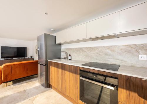 une cuisine avec des armoires blanches et un réfrigérateur en acier inoxydable dans l'établissement Appartement au pied des Calanques de Cassis, à Cassis