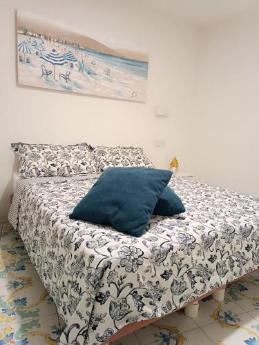 a bed with a blue pillow in a room at Il giardino dei limoni in Minori