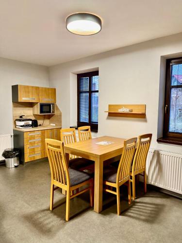 a dining room with a wooden table and chairs at Resort Mezná in Hřensko
