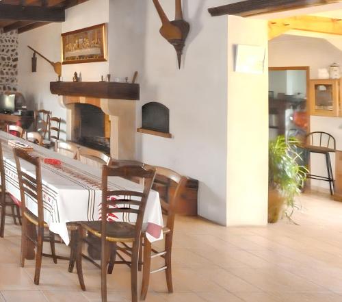 une salle à manger avec une table et une cheminée dans l'établissement Maison charmante à Bernac-Dessus avec jardin spacieux, à Bernac-Dessus