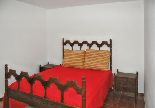 a red bed with two pillows on top of it at Spacious house with mountain view in Vila Fernando in Vila Fernando