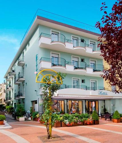 a large white building with balconies on a street at Petite Maison Lido in Cattolica