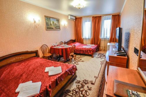 ein Hotelzimmer mit 2 Betten und einem Tisch in der Unterkunft Briz Hotel in Rjasan