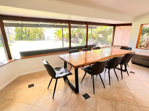 a dining room with a wooden table and chairs at Tropical family beach house in Holloways Beach